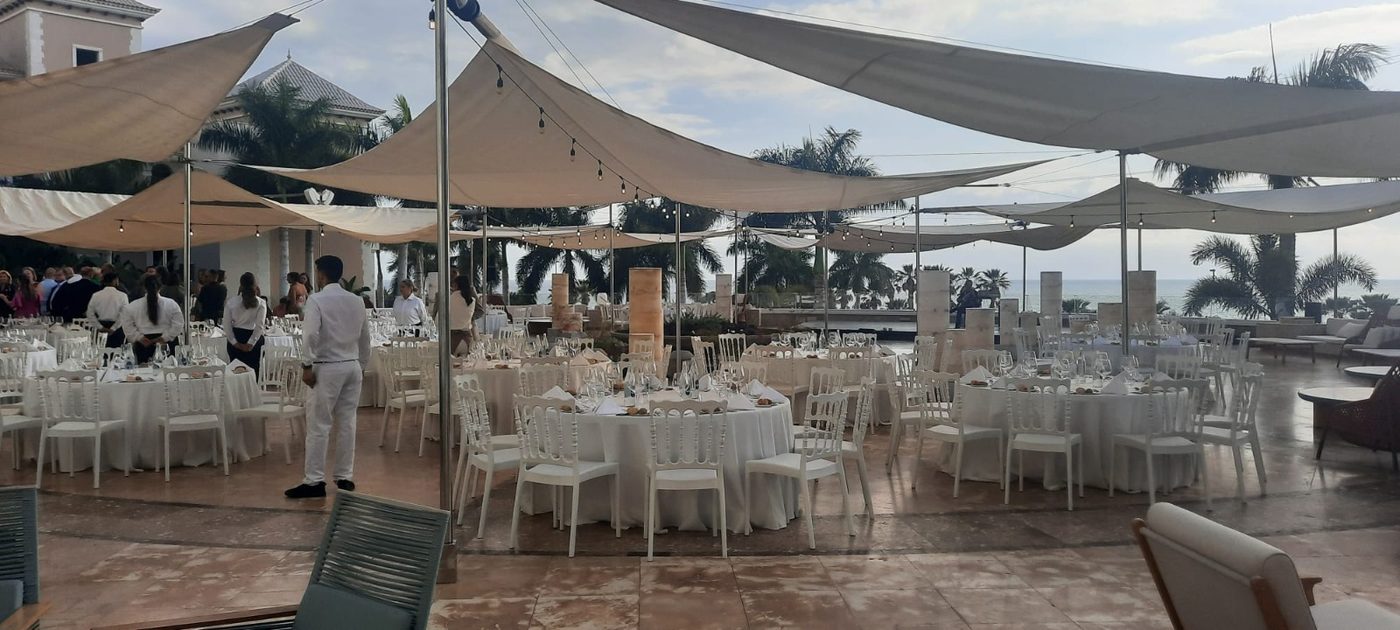 Wedding dinner under white shade sails on an open-air terrace